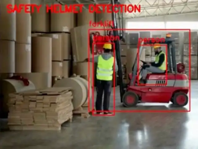 Recorded output in a warehouse: the label Safety Helmet Detection and boxes around two workers in helmets and high-visibility vests and a forklift.